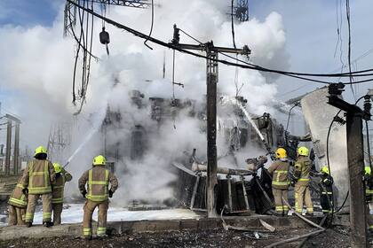 Esta imagen publicada el 22 de octubre de 2022 por el jefe de la Administración Estatal Regional de Rivne, Vitaliy Koval, muestra a los bomberos ucranianos extinguiendo un incendio en una infraestructura energética dañada por un ataque con misiles en la región de Rivne. 