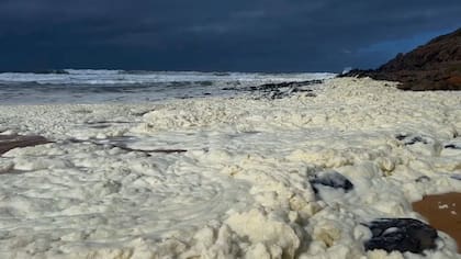Esta imagen tomada de un video proporcionado por la Australian Broadcasting Corp. muestra espuma en la orilla de una playa el lunes 17 de marzo de 2025, en Waitpinga, cerca de Adelaida. (Australian Broadcasting Corp via AP)