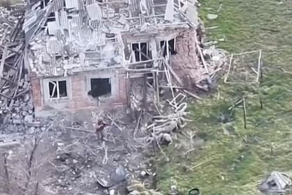 Esta imagen tomada de un video que oficiales militares europeos afirman fue grabado por un dron ucraniano en la aldea de Piatykhatky, en el sur de Ucrania, el 13 de marzo de 2025, muestra a un soldado, izquierda, identificado como ruso, apuntando con su arma a cuatro soldados ucranianos tirados en el suelo que aparentemente se rindieron