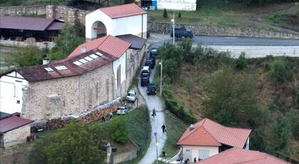 Esta imagen tomada y publicada por el gobierno de Kosovo el 24 de septiembre de 2023 muestra viviendas de evacuación de civiles, mientras un vehículo blindado está estacionado cerca de la entrada del monasterio de Banjska, en la aldea de Banjska en el norte de Kosovo.