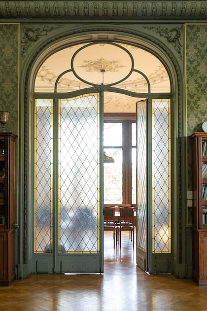 Esta puerta original del colegio Michael Ham con vitraux de Antoni Estruch es la entrada a la biblioteca. El detalle del empapelado con ribetes dorados combina perfectamente con los pisos de madera.  