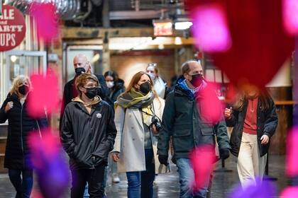 Shoppers wear masks while walking through an indoor market in New York, Wednesday, Feb. 9, 2022. New York Gov. Kathy Hochul announced Wednesday that the state will end a COVID-19 mask mandate requiring face coverings in most indoor public settings, but will keep masking rules in place in schools for now. (AP Photo/Seth Wenig)