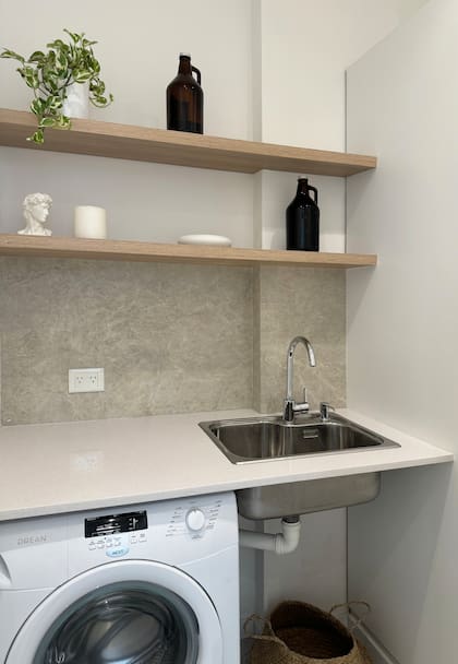 Estantes alacena (Melamina Camellia de Faplac). Bacha (Johnson Luxor mini), grifería (FV Puelo). Maceta y planta (Potit), dispenser (Apatheia), vela (Candle Shop), escultura David (Roma Doma) y plato de sitio cerámica (Cacharro x Lucía Cortegoso).