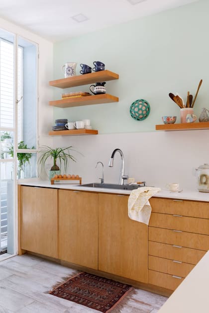 Estantes (BS Carpintería). Aplique de pared de cerámica (Sany Cerámicas). Mesadas de la cocina, barra y alzada en ‘Blanco puro’ de StoneQuartz (Marmolería Lanzavecchia).