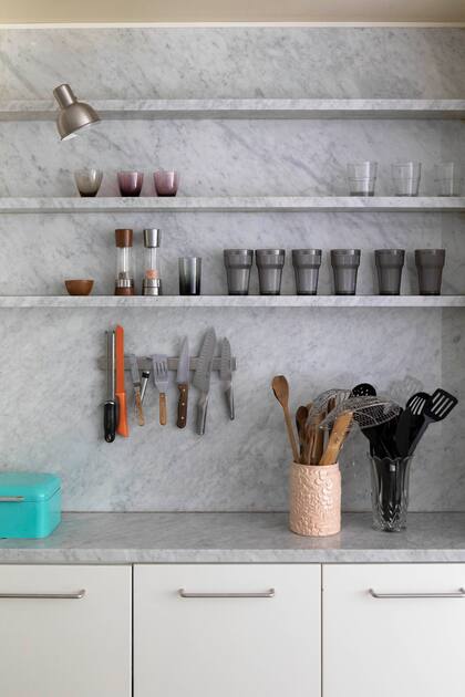 Estantes, mesada y alzada en mármol: un único criterio que cose todas las piezas.