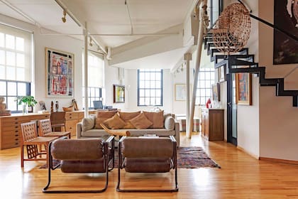 El living se organizó con un sillón tapizado en gris (Mariana Alvear), dos sillas como las del comedor y sillones individuales de los años 50 comprados en mercados de antigüedades.