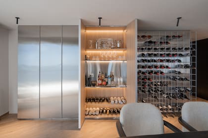 Este material frío se templa con la calidez del revestimiento interior en madera