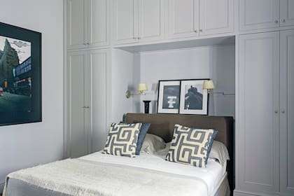 El cuarto de huéspedes se trabajó en grises y azules. Se armó un ropero donde empotrar la cama, con estante de apoyo detrás de la cabecera tapizada en lino (De Levie).