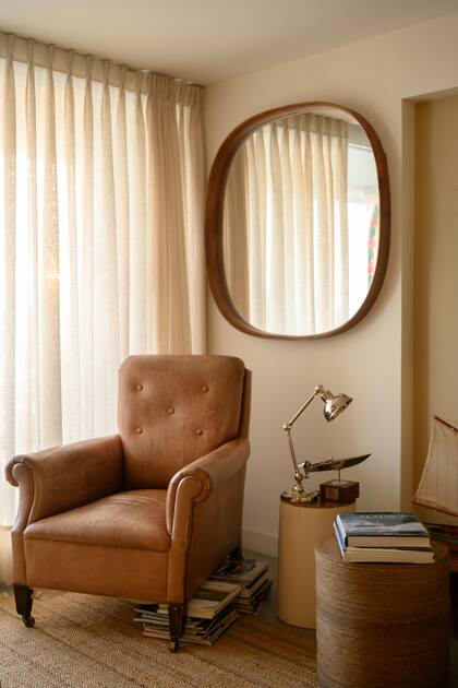 Este sillón Berger con capitoné de cuero Pancho lo tenía cuando su agencia funcionó en La Fontana. Arriba, un espejo para generar más espacio.