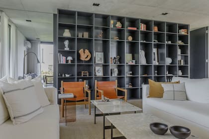 Este tramo de biblioteca divide el living del comedor diario, que continúa en un playroom. “Para equilibrar ese frente oscuro, incorporamos géneros claros”, detalla la arquitecta Mosteiro.