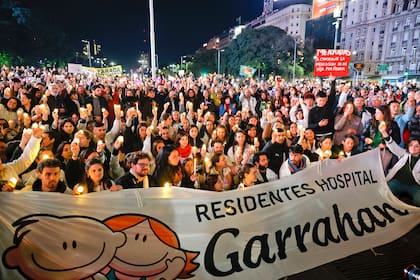 Esteban alza el cartel para pedir ayuda en la Noche de velas en el Obelisco, organizada por los trabajadores del Hospital Garrahan