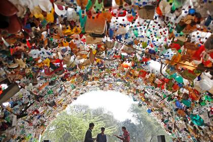 Estudiantes bajo un puente hecho de botellas de plástico usadas mientras participan en una protesta mundial contra el cambio climático en Gurugram, India