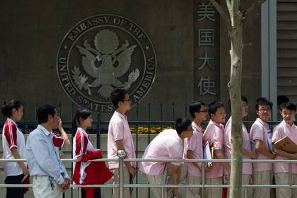 Estudiantes chinos esperan afuera de la Embajada de Estados Unidos para sus entrevistas de su solicitud de visa el 2 de mayo de 2012, en Pekín. (AP Foto/Alexander F. Yuan, Archivo)