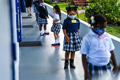 Estudiantes con distancia social en el primer día de clases en la St. Lawrence Catholic School, en el norte de Miami (Photo by CHANDAN KHANNA / AFP)