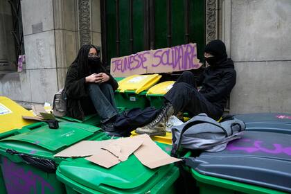 Estudiantes en huelga sentados en cubos de basura frente a su Universidad el martes 7 de marzo de 2023 en París