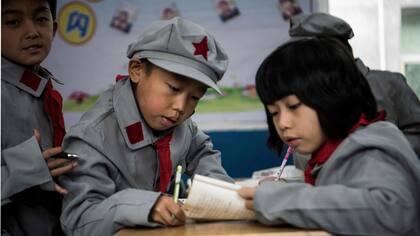 Estudiantes, hacen su tarea en la escuela primaria del "ejército rojo"