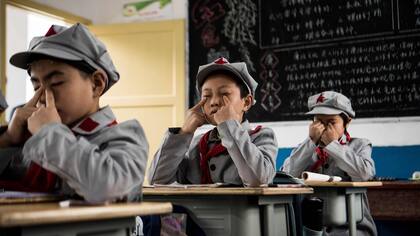 Estudiantes, haciendo "ejercicios de los ojos" para relajarse después de un intenso trabajo en la escuela primaria del "ejército rojo"