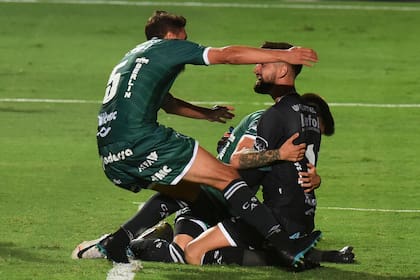 Vicentini, abrazado luego de atajar el penal decisivo y darle el ascenso a Sarmiento.