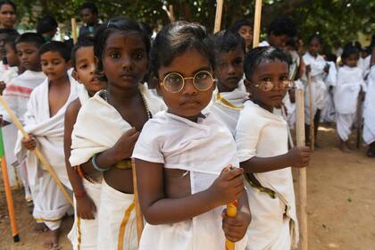 Estudiantes vestidos como Mahatma Gandhi hicieron una muestra en su escuela por el aniversario del nacimiento del activista