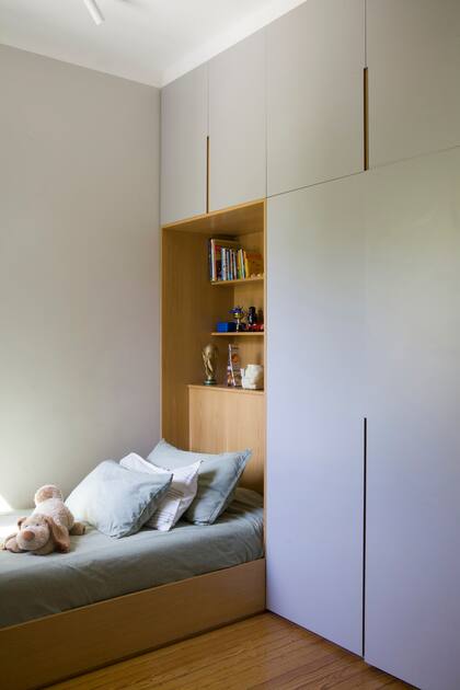 Estudio Planta diseñó para este cuarto infantil una pared de placares donde se inserta la cama con respaldo/biblioteca de fondo.