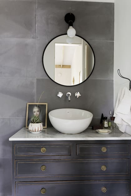 Eugenia acompañó el mueble reciclado con una bacha ‘Bol’ (Roca) y grifería 'Alerce' (FV) y un espejo circular (Mercado Libre).