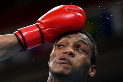 Euri Cedeño Martínez, de República Dominicana, recibe un puñetazo del argentino Francisco Daniel Verón, durante el combate de boxeo en la ronda preliminar masculina (69-75 kg) 