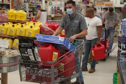 Evan Raggio y otras personas compran suministros en la ferretería Stine antes de la posible llegada del huracán Laura el 26 de agosto de 2020 en Lake Charles, Louisiana