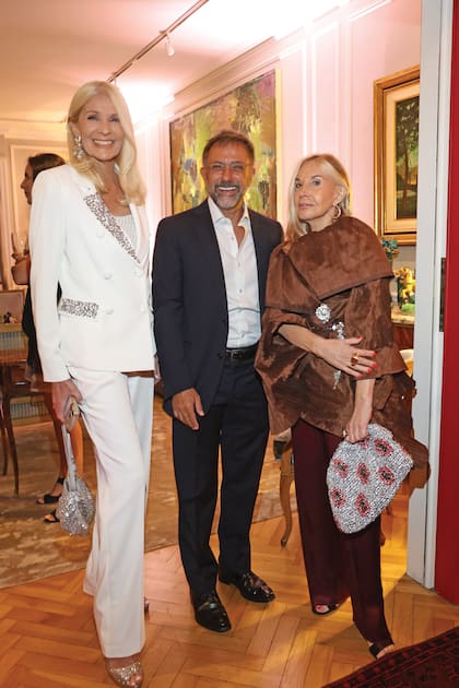 Evelyn Scheidl con un traje de saco y pantalón
blanco junto a Claudio Stamato y la interiorista
Roxana Punta Álvarez