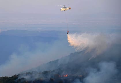 Evros (Grecia), 26/08/2023.- Un helicóptero de bomberos lanza agua durante las labores de extinción de un incendio forestal en la zona de Leptokarya, Evros, norte de Grecia, 26 de agosto de 2023. (incendio forestal, Grecia) EFE/EPA/DIMITRIS ALEXOUDIS
