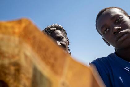 Al-Shabat, Sudán. Dos refugiados se preparan para abordar los autobuses que los llevarán al campo de Um Rakuba, ubicado un poco más lejos de la frontera con Etiopía.