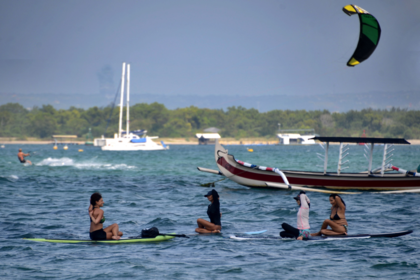 Extranjeros hacen yoga en tablas de remo en la playa de Sanur, en la isla turística de Bali, en Indonesia