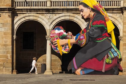 Gigantografía de una mujer montehermoseña con traje típico y gorra bordada, en la Plaza Mayor de Plasencia