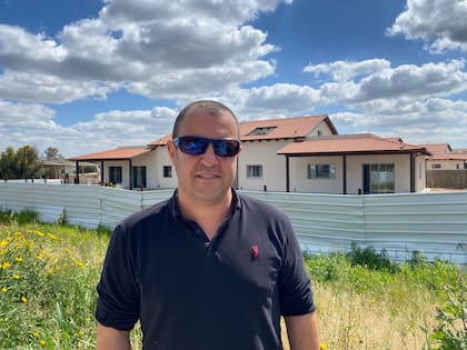 Eyal Ben Zvi y detrás las casas de un barrio recién construido a nuevo