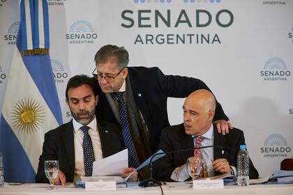 Ezequiel Atauche y Bartolomé Abdala, con el radical Eduardo Vischi (de pie) durante la reunión en comisión por la Ley de Bases