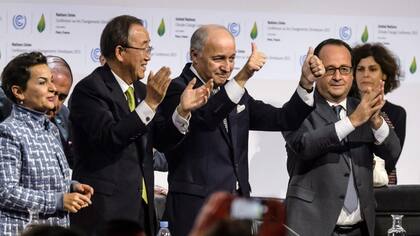 Fabius, presidente de la cumbre, flanqueado por Ban Ki-moon y Hollande tras al anuncio del acuerdo en París