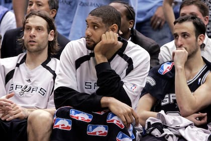 Fabricio Oberto y Manu Ginobili de San Antonio Spurs, ambos de Argentina, se sientan en la banca con su compañero de equipo Tim Duncan durante los minutos finales de su derrota ante Utah Jazz durante el Juego 3 de su final de la Conferencia Oeste de la NBA. serie en Salt Lake City, Utah