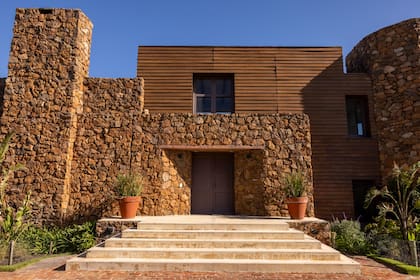 Fachada de la casa contruida con materiales de piedra y madera. 