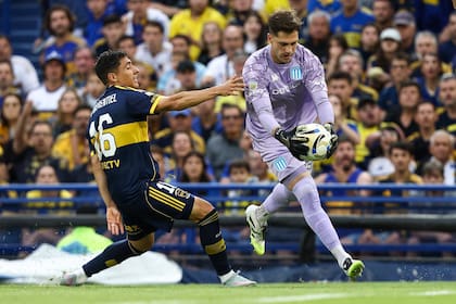 Facundo Cambeses gana la pelota ante Merentiel en el último Boca-Racing; el arquero es uno de los indiscutidos por la gente