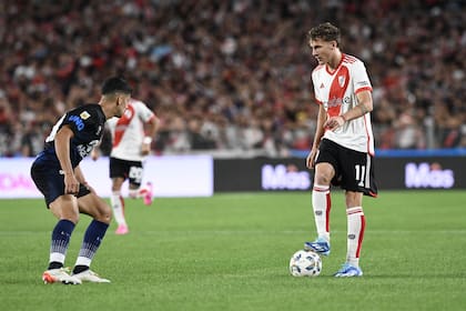 Facundo Colidio, uno de los mejores de River en el primer tiempo, controla la pelota ante Luciano Abecasis; el atacante sorprendió con la posición de wing izquierdo.