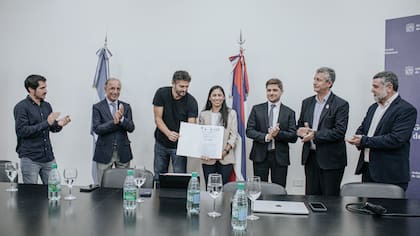 Facundo Sartori, ministro del Agro, y Emilce Errubidart, sostienen la póliza del seguro para proteger a los yaguaretés, a su izquierda, Juan Carlos Godoy, presidente de Rio Uruguay Seguros