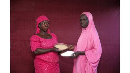 Falmata Madu intercambia su plato de arroz crudo por el maíz molido de Hadisa Adamu