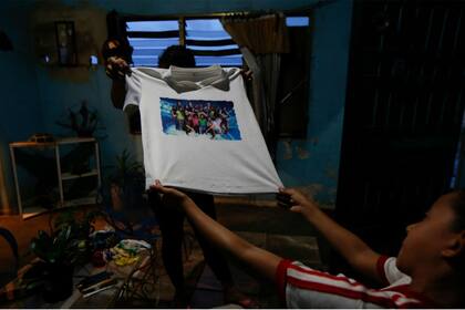 Familiares de Maroly muestran una remera de ella y su familia