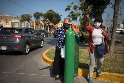Familiares de pacientes con Covid-19 hacen filas para poder recargar oxígeno, en Lima