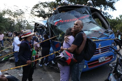 Familiares de víctimas de un atentado se abrazan frente a un autobús alcanzado por un artefacto explosivo en Cajibio, Colombia, el 25 de abril de 2026
