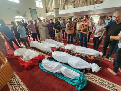 Familiares junto a los cuerpos de la familia Abu Dagga, muertos en un ataque aéreo israelí, durante su funeral en Khan Younis, sur de la Franja de Gaza, sábado 7 de octubre de 2023.