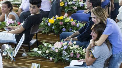 Familiares lloran a sus seres queridos en los ataúdes en la ceremonia de entierro