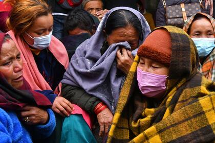 Familiares y allegados de las víctimas del accidente aéreo de Yeti Airlines lloran a las puertas de un hospital en Pokhara el 16 de enero de 2023. 
