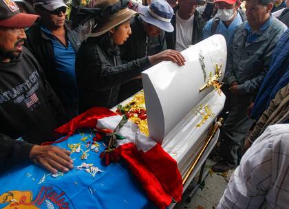 Familiares y amigos asisten al entierro del estudiante de 17 años Jamilath Aroquipa, uno de los 17 fallecidos durante el violento intento de tomar el aeropuerto de la ciudad de Juliaca el 9 de enero, en el cementerio de Capilla en Juliaca, sur de Perú, el 12 de enero de 2023.