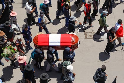 Familiares y amigos de las víctimas de los enfrentamientos con la policía peruana cargan sus féretros en la ciudad andina de Juliaca, en el sur de Perú, el 11 de enero de 2023. (Juan Carlos CISNEROS / AFP)