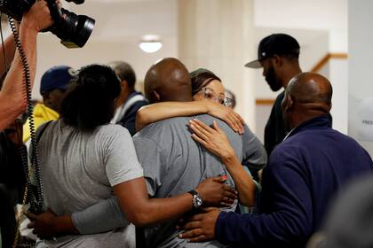 Familiares y amigos de Winnie Madikizela Mandela, ex esposa del ex presidente sudafricano Nelson Mandela, reaccionan en el hospital Milpark en Johannesburgo, el 2 de abril de 2018